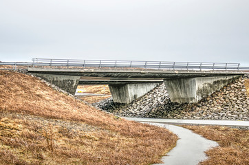 Robust concrete viaduct in a highway near Reykjavik, Iceland, with a secondary road passing underneath