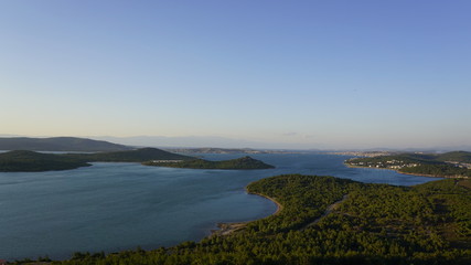Fototapeta na wymiar Landscape of Devil's Table (Seytan Sofrasi) in Ayvalik, Aegean District in Turkey. Blue and green collaboration. Aerial view of famous touristic place as known Seytan Tepesi. High altitude. Acrophobia