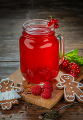 glass jar with delicious healthy hot raspberry tea and gingerbread man