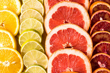 Flat lay slices of different raw fresh citrus fruit.