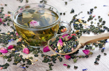 green tea. cup of green tea with flowers and fruit pieces. blend tea