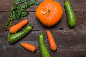 Layout with vegetables - pumpkin, zucchini and parsley on old wooden table with copy space.