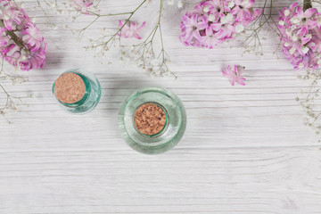 Abstract composition of purple hyacinths flowers and bottles of organic cosmetic with essential oil