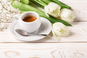 Fototapeta na wymiar Spring tulips and coffee on a white wooden background close-up. Mother's day background, women's day, morning Birthday