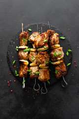Grilled meat skewers, shish kebab on black background, top view
