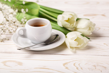 Obraz na płótnie Canvas Spring tulips and coffee on a white wooden background close-up. Mother's day background, women's day, morning Birthday