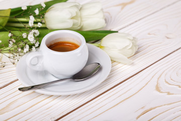 Spring tulips and coffee on a white wooden background close-up. Mother's day background, women's day, morning Birthday