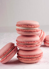 pink macarons dessert on white texutured background