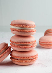 selective focus of pink stack with macarons dessert on white texutured background