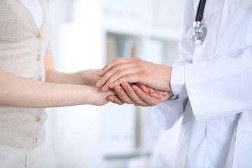 Hand of doctor reassuring her female patient. Medicine and health care concept