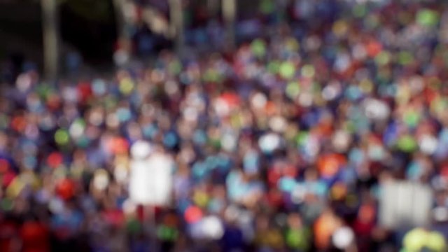 Large number of men and women take part in the annual spring mass marathon race on the blooming streets in the morning, on the start line, in blurred video