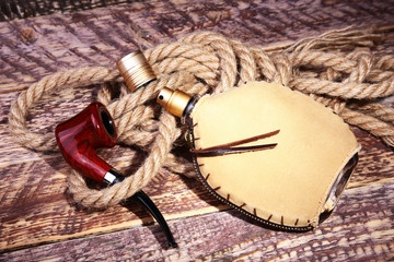 Smoking pipe and eau de cologne. Men's recreation accessories on wooden table.