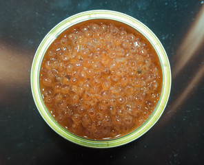 Bank of red caviar on the table top view