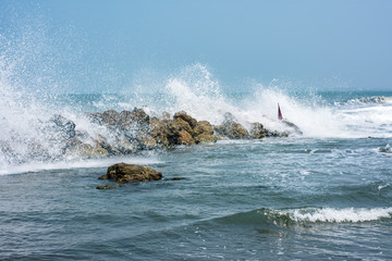 The waves crash against the rocks