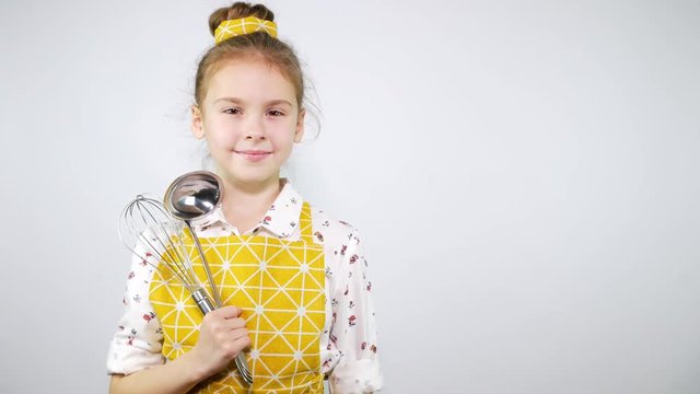 The girl in the apron as a professional chef looks into the camera. Background for text