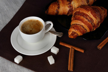 White Cup of coffee with a pair of delicious croissants