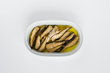 Sprats in oil, ceramic jar. White background, top view, space for text.