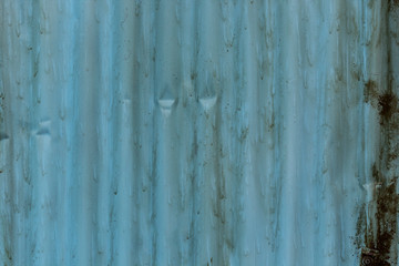 Background: Blue corrugated sheet with rust spots