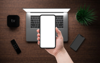 Woman holding smartphone with blank screen.