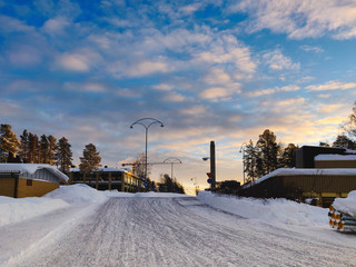 winter landscape with trees and buildings around under the blue sky