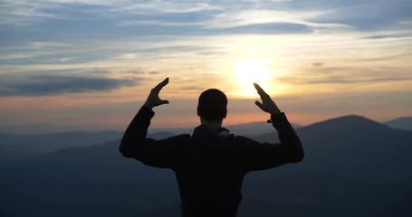 4k slow motion - Man on the top of the world praying to god at sunset
