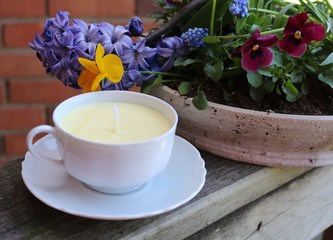 Candle in cup of tea with flowers