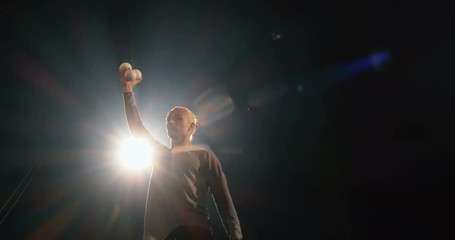 4k - Juggler in the black studio make tricks with balls.