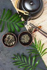 Black iron teapot and traditional ceramic cup of tea
