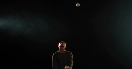 Artist of circus juggling on the black stage.