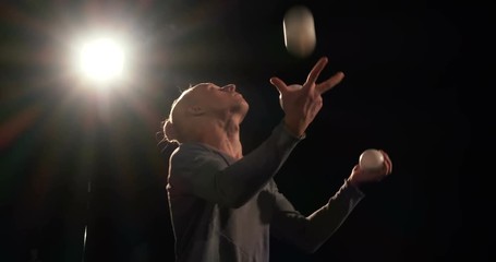 Juggler on the stage makes tricks with 7 ball and have a fail.