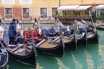 Fototapeta na wymiar Venise, alignement de gondoles amarrées sur un canal (Italie)