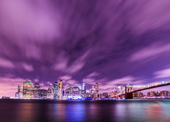 Fototapeta premium Manhattan panoramic skyline at night with Brooklyn Bridge. New York City, USA. Office buildings and skyscrapers at Lower Manhattan (Downtown Manhattan).