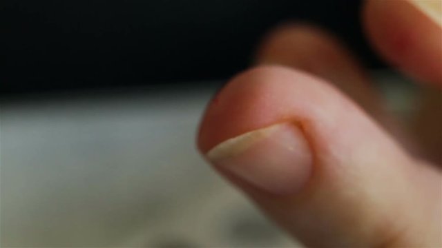 An adult woman independently makes a rapid test for diabetes. Super close-up. A woman pierces the skin with a disposable pen-Lancet, squeezes out a drop of blood.  Real time, natural light, shallow de
