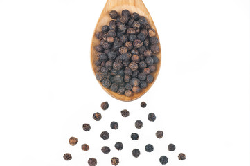 Close up heap of black pepper in wooden spoon, peppercorns isolated on white background, dried spice pepper corn concept