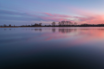 Naklejka na ściany i meble Calm lake and pink clouds after sunset