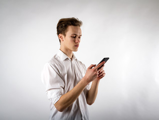 Young man in white using smartphone