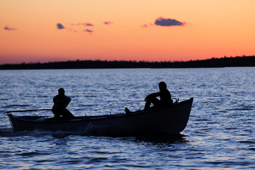 Naklejka premium Wooden boat on sunset 