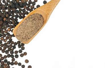 Close up heap of black pepper in wooden spoon, peppercorns and milled pepper powder isolated on...