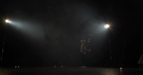 Amazng circus juggler makes tricks on the stage.