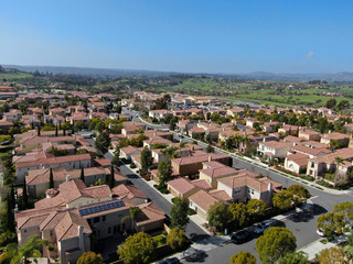 Fototapeta na wymiar Aerial view suburban neighborhood with identical wealthy villas next to each other. San Diego, California, USA. Aerial view of residential modern subdivision luxury house with swimming pool.