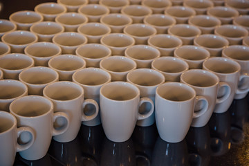 Many white cups on black table