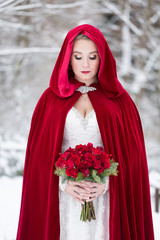 Beautiful winter bride wearing red cape