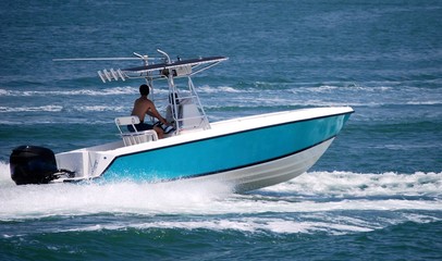 Open sport fishing boat light blue with white trim speeding on the Florida Intra-Coastal Waterway off  Miami Beach. © richard pross