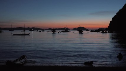 Traditional philippine boat bangka at sunset time. Beautiful sunset with silhouettes of philippine boats in El Nido, Palawan island, Philippines.