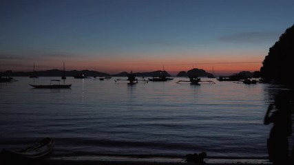 Traditional philippine boat bangka at sunset time. Beautiful sunset with silhouettes of philippine boats in El Nido, Palawan island, Philippines.