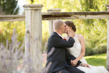 bride and groom sitting and kissing