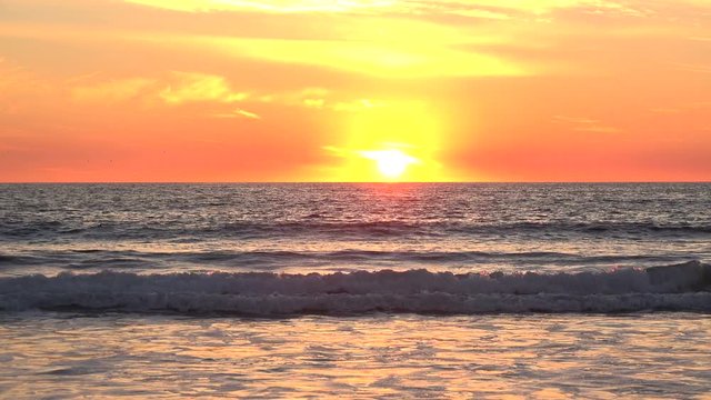 Beautiful reflections in the ocean during a brilliant orange sunset