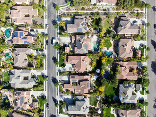 Aerial view suburban neighborhood with identical wealthy villas next to each other. San Diego, California, USA. Aerial view of residential modern subdivision luxury house with swimming pool.