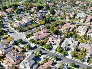 Fototapeta na wymiar Aerial view suburban neighborhood with identical wealthy villas next to each other. San Diego, California, USA. Aerial view of residential modern subdivision luxury house with swimming pool.
