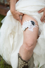 Bride showing gun held in lacy garter on leg